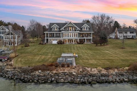 Immerse yourself in the epitome of luxury with this 1.5+ acre site with 143' of pristine sandy Big Green Lake frontage and panoramic lake views. This nearly 8,000 sq. ft. opulent estate has 3 family rooms, a massive recreational room, office, 8 bedro...
