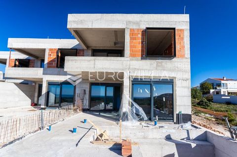 Primošten, triple luxury villa under construction with sea view. Total net living area 108.60 m2. It extends over two floors, ground floor and first floor. On the ground floor of the villa there is an entrance area, a kitchen, a dining room and an op...