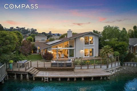 This serene waterfront home is located on a quiet cul de sac bordering a wide expanse of the Belvedere Lagoon. A vaulted ceiling and disappearing walls of glass frame views of the sparkling lagoon from the airy living room, marble-clad kitchen, and l...