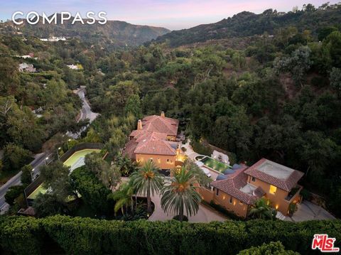 Secluded behind private gates and surrounded by lush, vibrant greenery, this Mediterranean-inspired tennis court estate offers resort-like living in the most exclusive estates section of Benedict Canyon. Set on over 1.5 acres of serene land, the prop...