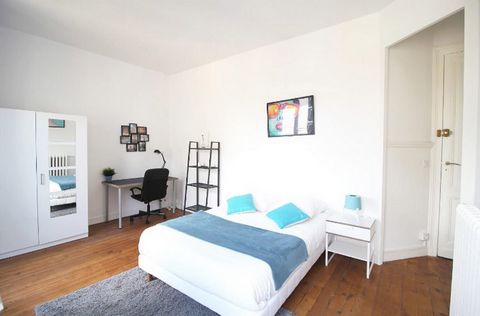 Very spacious room of 18m², fully furnished. It features a double bed (140x190) accompanied by a bedside table with a lamp. A workspace is available, consisting of a desk with a chair and a lamp. The room also offers several storage options: a wardro...