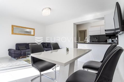 Trogir, modern one-bedroom apartment in a newly built building, available for rent all year round. The apartment is located on the second floor of the building, and is divided into a hallway, bathroom, bedroom, kitchen with dining room, living room a...