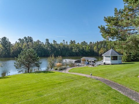 Neuwertiges Haus mit 4 Schlafzimmern und 5 Bädern an der Eagle River / Three Lakes-Kette von 28 Seen, das sich auf einem sorgfältig gepflegten Grundstück mit 179' zerrissener Wasserfront und direkt gegenüber dem 1. Fairway des Eagle River Golf Course...