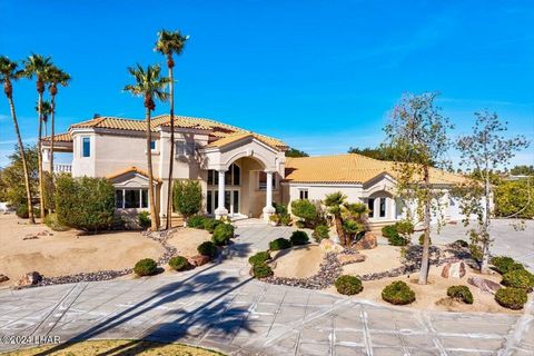 Looking for over an acre property in Havasu? It's a very RARE opportunity to find such a beautiful privately gated Estate tucked in between the 9th & 18th holes of the prestigious Lake Havasu City Golf Club. The Estate is on a 1.4 acre lot with 365-d...