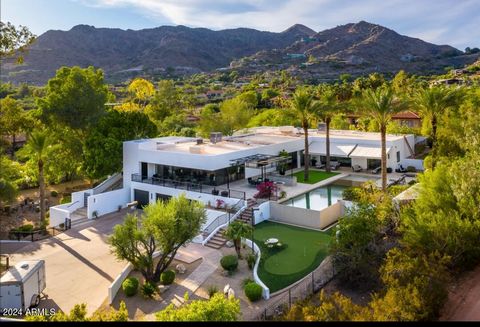 Discover unparalleled luxury at this gated 2-acre Paradise Valley estate, offering stunning views of Camelback Mountain and city lights through floor-to-ceiling glass walls. The gourmet kitchen is a chef's dream, complemented by a wet bar and wine ro...